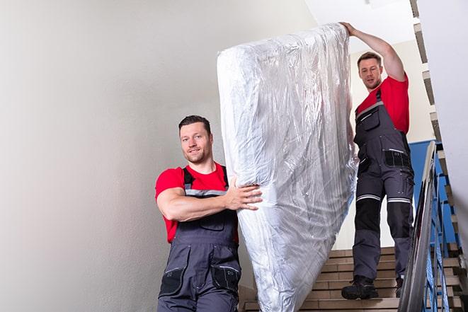 junk removal crew taking away box spring in Babylon